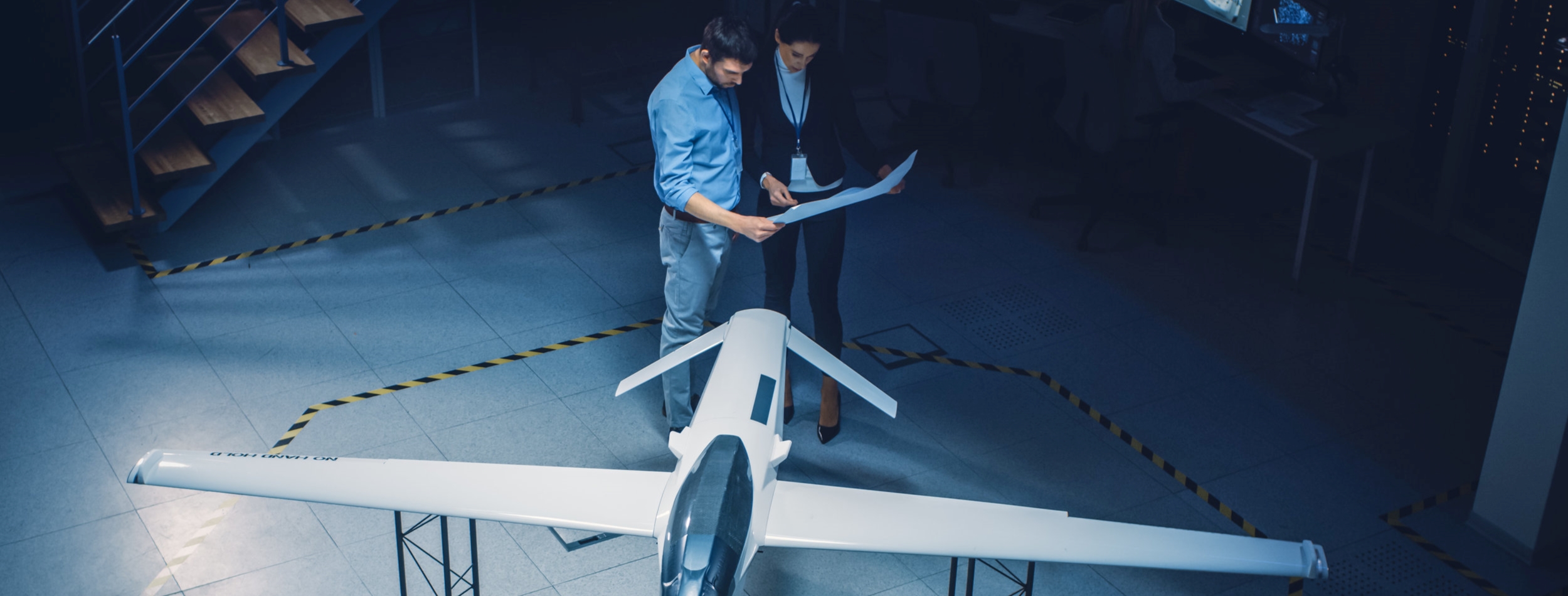 Meeting of Aerospace Engineers Work On Unmanned Aerial Vehicle Drone Prototype. Aviation Experts have Discussion. Industrial Facility with Aircraft Capable of GPS Surveillance and Military Missions
