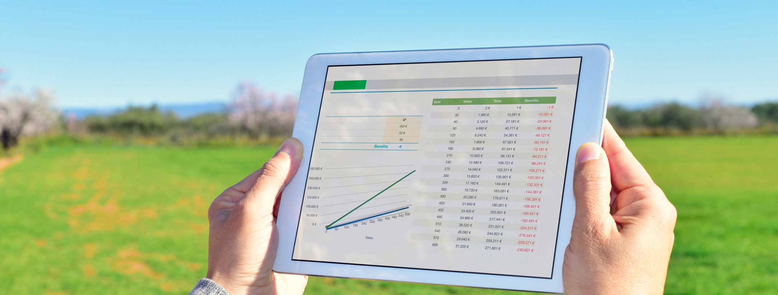 man observing some charts in a tablet in a fallow field