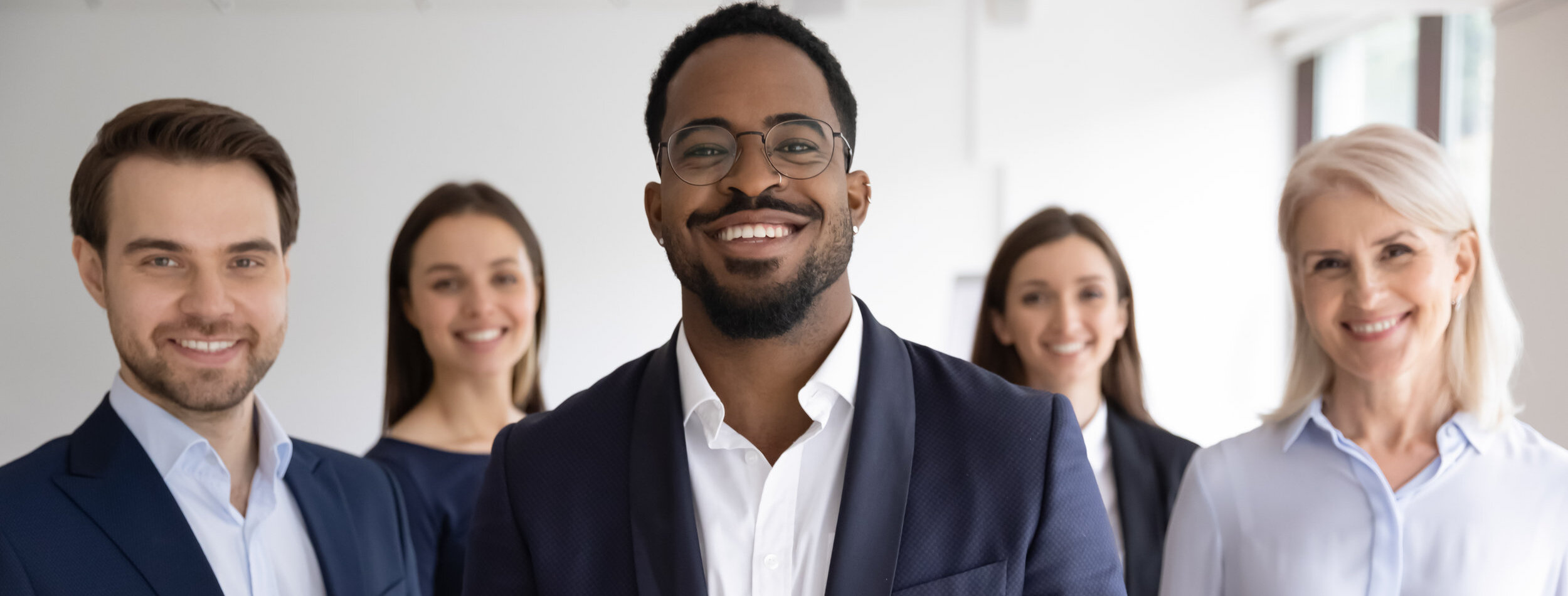 Diverse professionals bank employees company staff members in formal wear, 5 businesspeople lead by African ethnicity leader posing standing together in office. Young aged specialists portrait concept