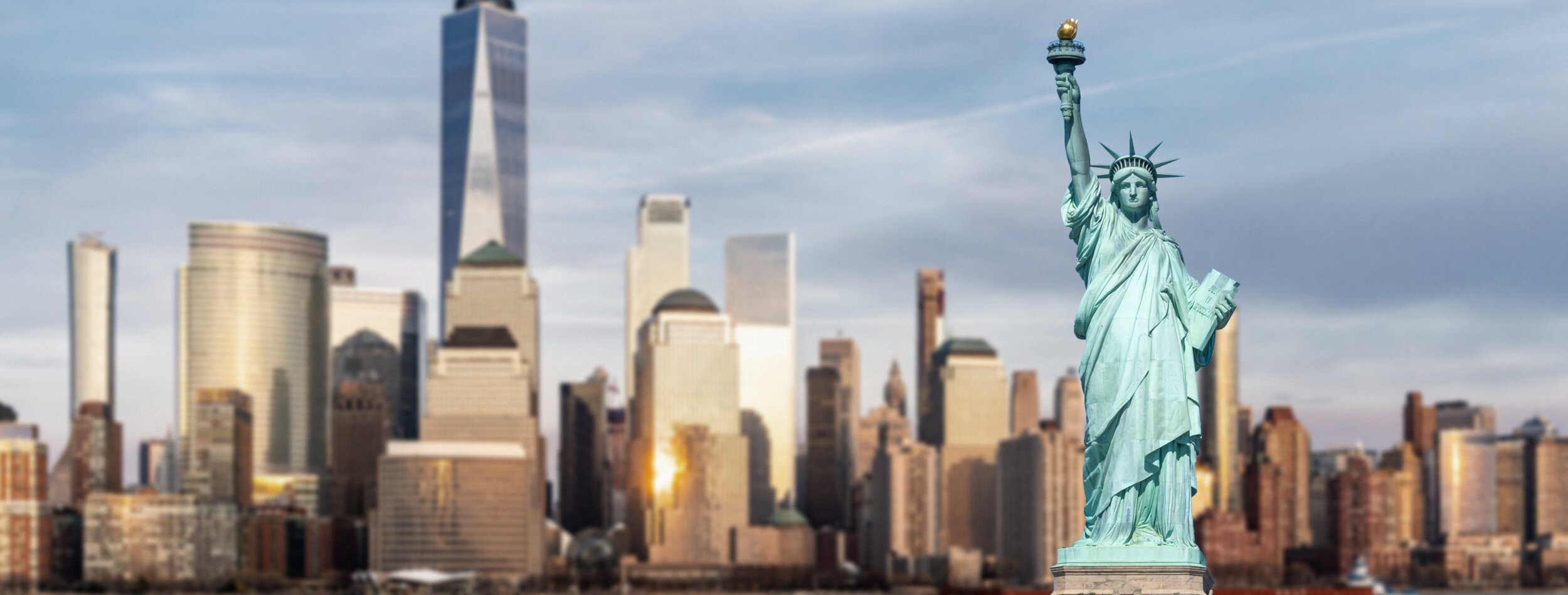 Statue of Liberty with background of New York city Manhattan skyline cityscape at sunset from New Jersey.